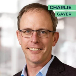 A man with glasses and short hair smiles at the camera. The name "Charlie Gayer" is written in the top right corner.