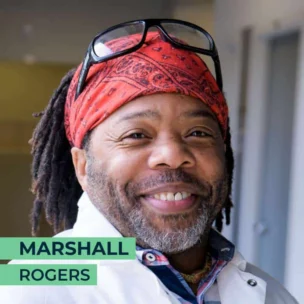 A man wearing a red bandana and glasses on his head smiles warmly. Text in the image reads "Marshall Rogers".