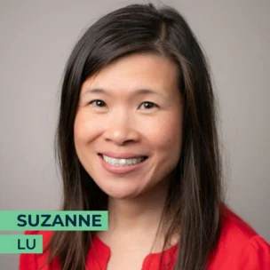 A woman with long dark hair smiles at the camera. She is wearing a red top. The text "Suzanne Lu" is displayed in the bottom left corner.